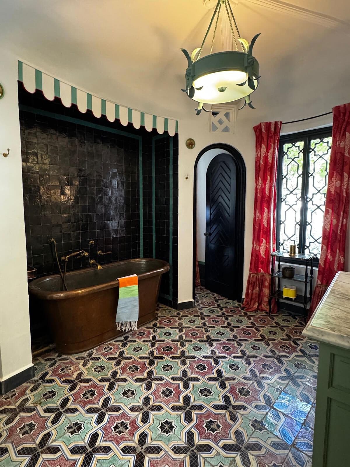 Riad en la Kasbah — Kasbah, Tánger Bañera de cobre bajo una hornacina de zellige negro con guardamalleta a rayas verdes — riad en la Kasbah, Tánger (Coco House)