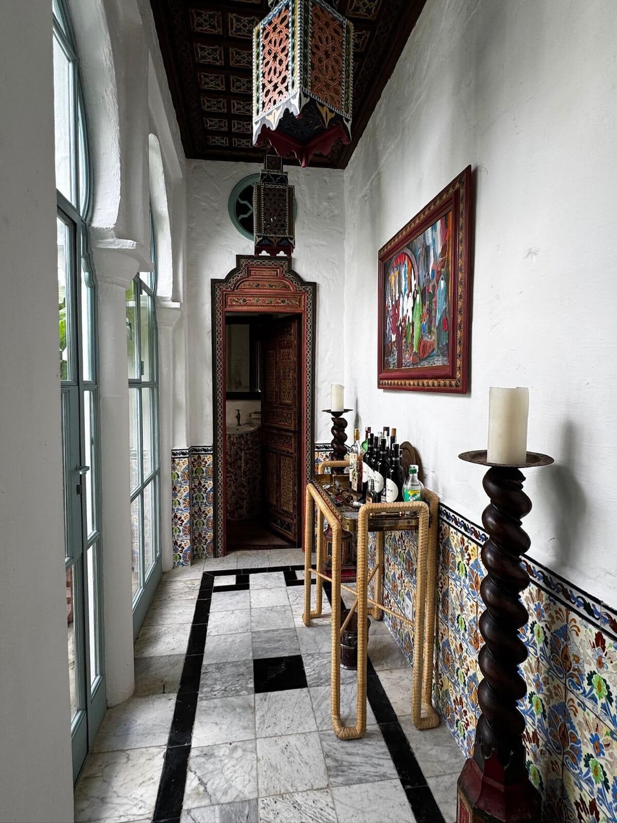 Riad en la Kasbah — Kasbah, Tánger Corredor con zócalo de azulejo, puerta tallada policromada y suelo de mármol — riad en la Kasbah, Tánger (Coco House)